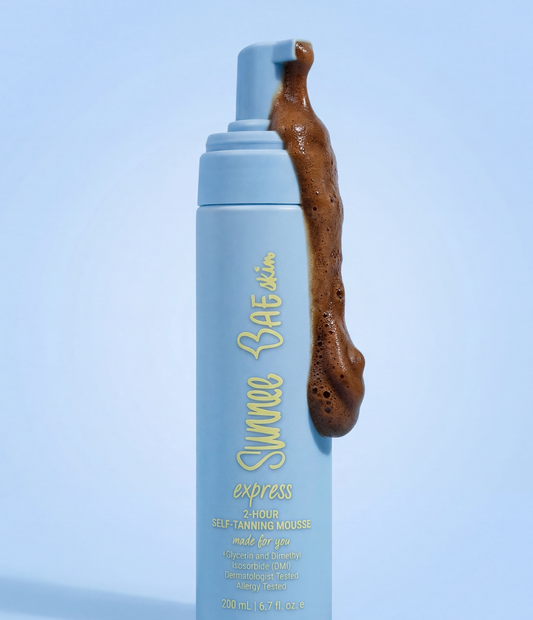 Blue bottle of Sunnee Baeskin Express 2-Hour Self-Tanning Mousse with brown mousse on a light blue background
